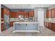 Modern kitchen with wood cabinets, stainless appliances, center island, and neutral countertops at 7288 Olsen Farm St, Las Vegas, NV 89131