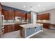 Spacious kitchen with wood cabinets, stainless appliances, center island, and neutral countertops at 7288 Olsen Farm St, Las Vegas, NV 89131