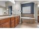 Beautiful bathroom with dual sinks, soaking tub, tile flooring, and custom design elements at 7288 Olsen Farm St, Las Vegas, NV 89131