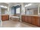 Luxurious bathroom boasting dual vanities, soaking tub, glass block window and ceramic tile floor at 7288 Olsen Farm St, Las Vegas, NV 89131