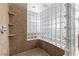 Contemporary shower features glass block wall, tiled surround, and recessed shelving at 7288 Olsen Farm St, Las Vegas, NV 89131