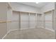 Spacious walk-in closet with neutral walls, tan carpet, and built-in shelving at 7288 Olsen Farm St, Las Vegas, NV 89131