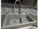 Close-up of a modern stainless steel kitchen sink with stylish faucet and tiled backsplash, adding elegance at 7904 Greycrest Ct # 104, Las Vegas, NV 89145