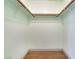 Bright walk-in closet featuring wood laminate flooring and hanging rods at 8113 Dolphin Landing Dr, Las Vegas, NV 89128
