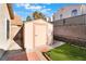 Backyard shed with brick pavers, artificial grass, and retaining wall at 8113 Dolphin Landing Dr, Las Vegas, NV 89128