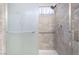 Shower featuring stone-look tiling, a glass door, and a shower head at 8113 Dolphin Landing Dr, Las Vegas, NV 89128