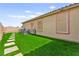 Featuring artificial turf, a concrete walkway, and a view of the pool beyond the fence at 820 Wintersweet Rd, Henderson, NV 89015