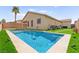 Beautiful backyard featuring an in-ground pool, artificial turf, and a mature palm tree at 820 Wintersweet Rd, Henderson, NV 89015