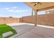 Spacious backyard featuring a covered patio with fan and a well-maintained lawn at 820 Wintersweet Rd, Henderson, NV 89015