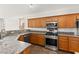 Well-lit kitchen featuring stainless steel appliances, granite countertops, and oak cabinetry at 820 Wintersweet Rd, Henderson, NV 89015