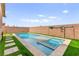 Sparkling in-ground pool and spa with artificial turf and stone paver accents at 820 Wintersweet Rd, Henderson, NV 89015