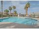 Community pool surrounded by palm trees and well-maintained landscaping near residential buildings at 8410 Eldora Ave # 2067, Las Vegas, NV 89117