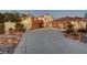 Elegant home exterior with stone accents, mature landscaping, and three-car garage at 8470 S Pioneer Way, Las Vegas, NV 89113