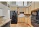 Kitchen featuring wood cabinets, black appliances, and earth-toned countertops at 8470 S Pioneer Way, Las Vegas, NV 89113