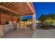 Outdoor kitchen under pergola with stainless steel grill and countertop space overlooking the in-ground pool at 8470 S Pioneer Way, Las Vegas, NV 89113