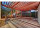 Covered patio area with brick flooring, stone accents, and views of the backyard landscaping and mature trees at 8470 S Pioneer Way, Las Vegas, NV 89113