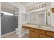Well-lit bathroom featuring a vanity with ample counter space, a large mirror, and a glass-enclosed shower at 8620 Prairie Hill Dr, Las Vegas, NV 89134