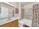 Clean bathroom with wood vanity, tub/shower combo, and floral shower curtain at 8620 Prairie Hill Dr, Las Vegas, NV 89134