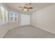 Bright bedroom featuring carpet floors, ceiling fan, and large windows with shutters at 8620 Prairie Hill Dr, Las Vegas, NV 89134