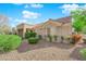 Attractive single-story home featuring desert landscaping, large windows, and a tile roof under a bright blue sky at 8620 Prairie Hill Dr, Las Vegas, NV 89134