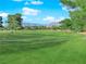 Expansive view of lush green golf course with distant mountains in the background on a bright day at 8620 Prairie Hill Dr, Las Vegas, NV 89134