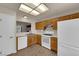 Efficient kitchen offers wood cabinets, white appliances, and a pass-through window to the dining area at 8620 Prairie Hill Dr, Las Vegas, NV 89134
