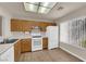 Well-lit kitchen features wood cabinets, white appliances, and wood-look flooring at 8620 Prairie Hill Dr, Las Vegas, NV 89134