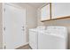 Functional laundry room with washer, dryer, storage, and exterior door at 8620 Prairie Hill Dr, Las Vegas, NV 89134