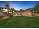 Expansive backyard with lush grass, palm trees, desert landscaping, and a swimming pool at 9 Quail Run Rd, Henderson, NV 89014
