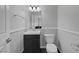 Well-lit half bathroom with a modern sink, dark wood vanity, and a classic white toilet at 9 Quail Run Rd, Henderson, NV 89014