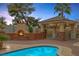Inviting backyard fireplace and covered patio area overlooking a sparkling pool at 9 Quail Run Rd, Henderson, NV 89014