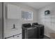 Modern laundry room with gray washer/dryer, a sink, a cabinet, and shelving at 9 Quail Run Rd, Henderson, NV 89014