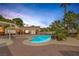 Backyard features a sparkling pool, covered patio, brickwork, mature palms and desert landscaping at 9 Quail Run Rd, Henderson, NV 89014