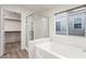 Bright bathroom featuring a large soaking tub, glass shower, and convenient access to the walk-in closet at 9006 Cedar Door Ave, Las Vegas, NV 89148