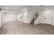 Spacious living room featuring laminate flooring and an open layout leading to the kitchen and staircase at 9006 Cedar Door Ave, Las Vegas, NV 89148