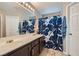 Clean bathroom featuring double sink vanity, floral shower curtain, and neutral color palette at 9465 Milkweed Canyon Ave, Las Vegas, NV 89166