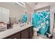 Bright bathroom featuring single sink vanity, shower with curtain, and ample countertop space at 9465 Milkweed Canyon Ave, Las Vegas, NV 89166