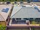 Backyard aerial shot showcasing gray tile roof, brick patio, solar panels, and a desert landscape at 9608 Bloodstone Ln, Las Vegas, NV 89143