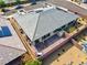 Stunning backyard aerial shot featuring a gray tile roof, brick patio, solar panels, and desert landscape at 9608 Bloodstone Ln, Las Vegas, NV 89143