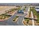 Aerial view of a well-manicured community entrance with a security gate, landscaping, and palm tree-lined street at 9608 Bloodstone Ln, Las Vegas, NV 89143