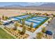 Aerial image showcasing multiple blue pickleball courts surrounded by desert landscaping, trees and parking at 9608 Bloodstone Ln, Las Vegas, NV 89143