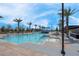 A stunning swimming pool surrounded by lounge chairs and mature palm trees at 9608 Bloodstone Ln, Las Vegas, NV 89143