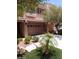 Tan two-story home with a two-car garage, desert landscaping, and a concrete driveway at 9758 Panther Hollow St, Las Vegas, NV 89141