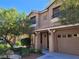 Tan two-story home featuring a two car garage, balcony, desert landscaping and covered front porch entry at 9758 Panther Hollow St, Las Vegas, NV 89141