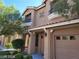 Tan two-story home featuring a two car garage, balcony, desert landscaping and covered front porch entry at 9758 Panther Hollow St, Las Vegas, NV 89141