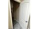 Hallway with modern wood-look flooring leads to a living area and a doorway with a closed white door at 9758 Panther Hollow St, Las Vegas, NV 89141