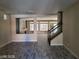 Neutral interior with gray plank flooring, open floorplan, staircase, and fireplace in the next room at 9758 Panther Hollow St, Las Vegas, NV 89141