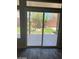 Patio doors open to a well-maintained backyard with lush greenery and privacy fencing at 9758 Panther Hollow St, Las Vegas, NV 89141