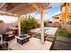 Backyard patio with outdoor kitchen, pergola, fire pit and inviting pool with artificial grass at 1017 Fairbury St, Henderson, NV 89052