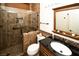 Beautiful bathroom with a tiled shower, glass door, dark granite countertop, and framed mirror at 1017 Fairbury St, Henderson, NV 89052
